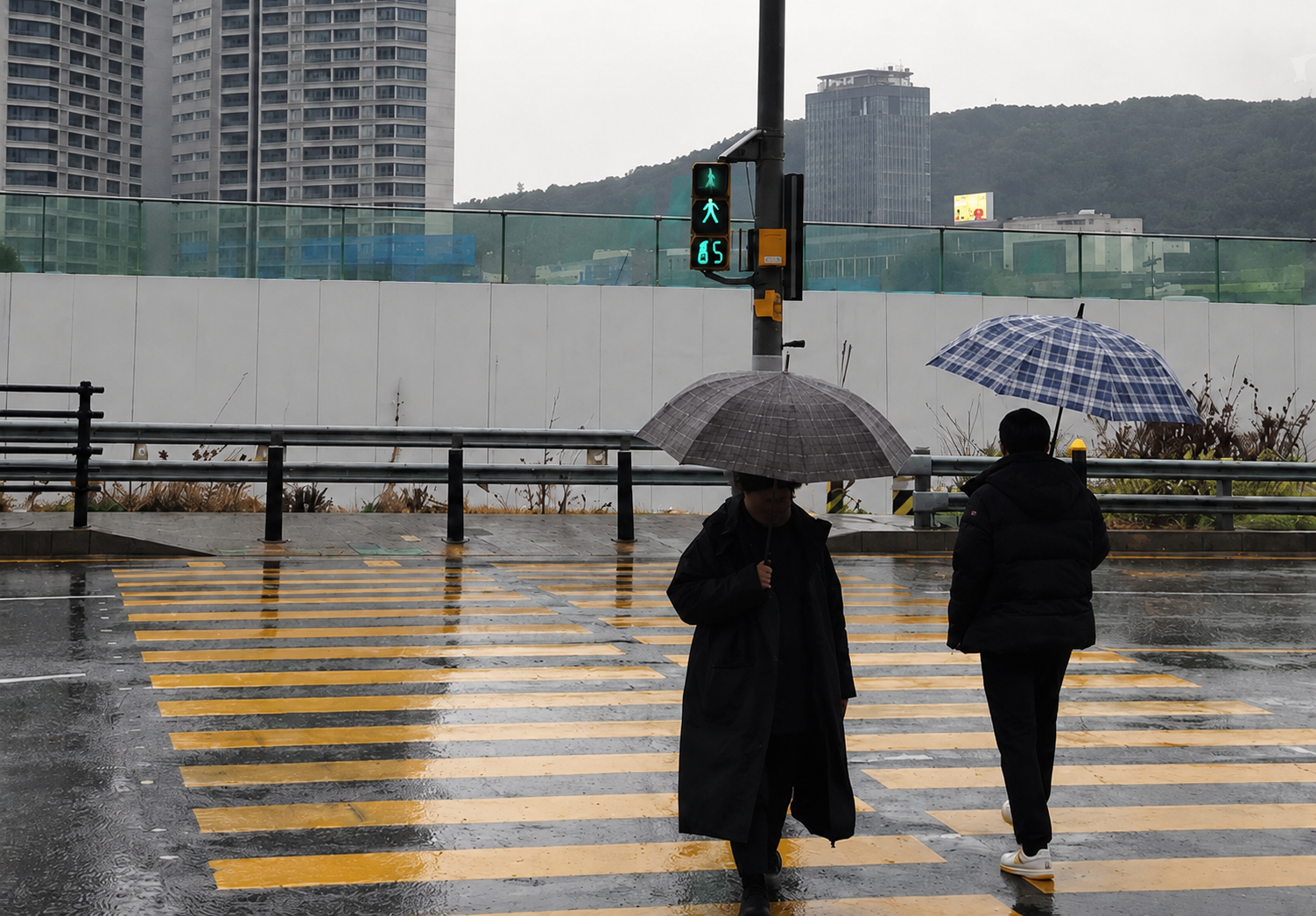 우천 시 스마트횡단보도 현장: 보행 신호와 우산을 쓴 보행자